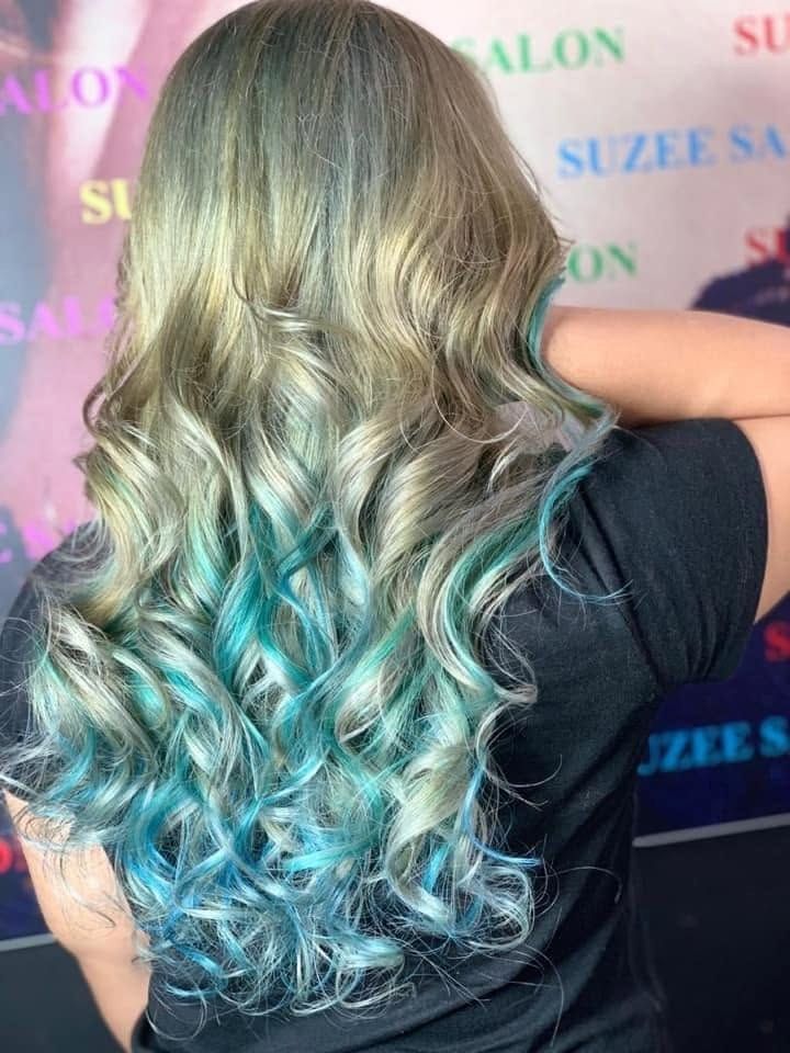 Rambut panjang keriting warna blonde dengan hujung biru teal, dilihat dari belakang